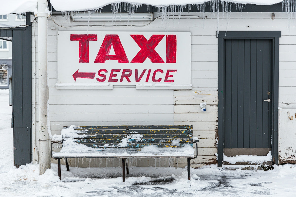 a bench sitting outside of a building covered in snow