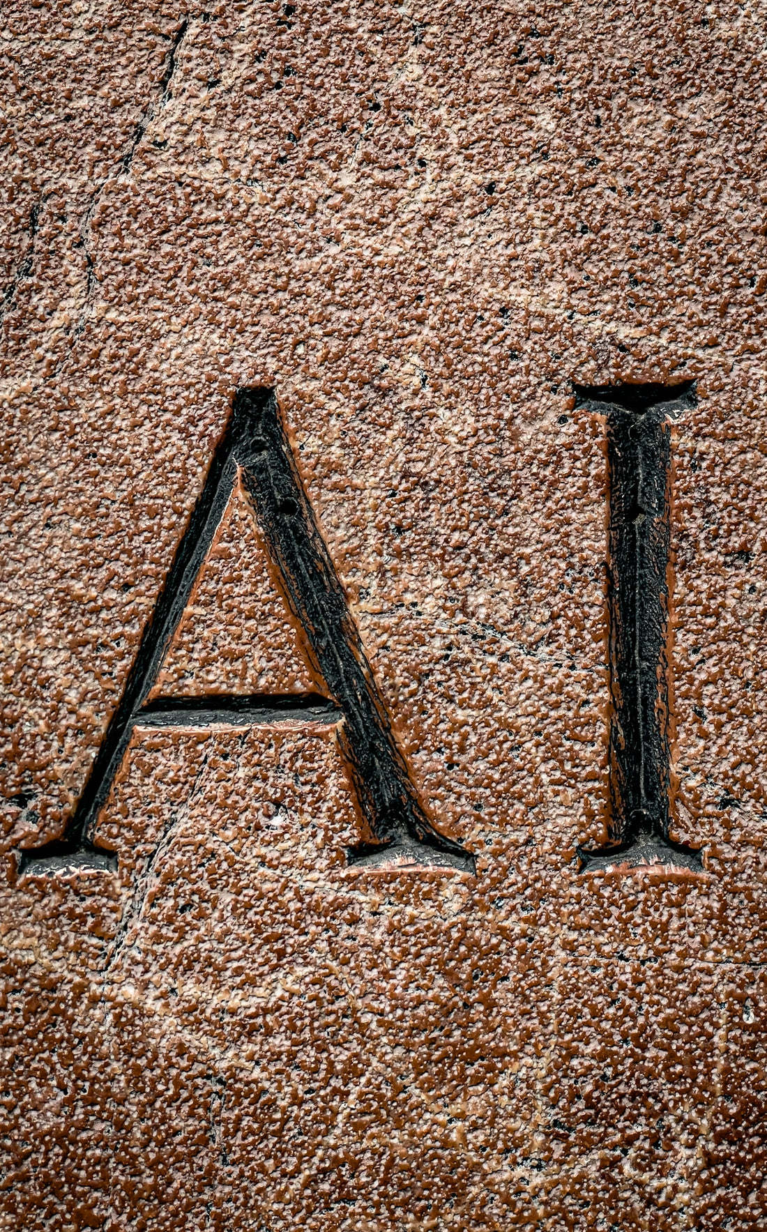 The letters ai are carved into a stone.